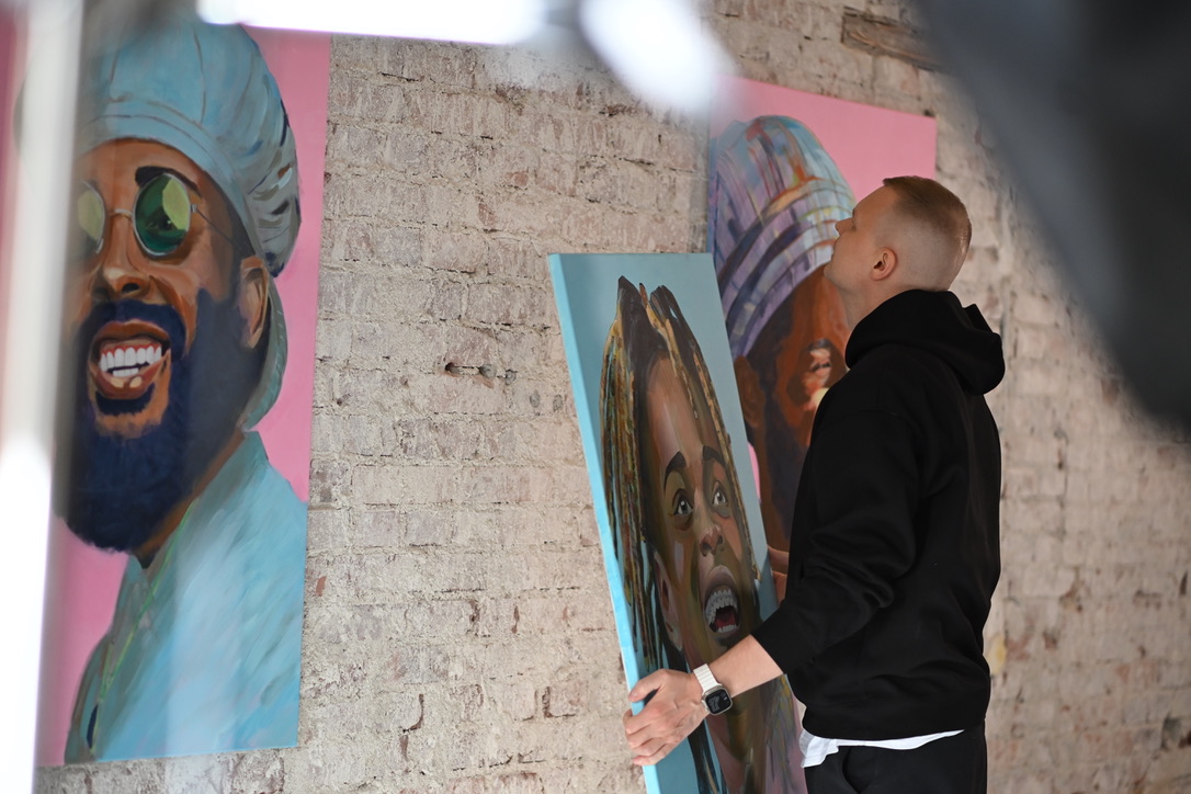 Artist in profile looking at painting